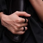 woman's hands with black rings holding binder