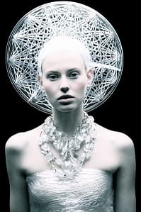 pale girl wearing white plastic headdress and necklace