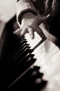 child's finger on piano key