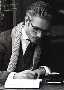 male model Benoit in scarf and coat writing at table