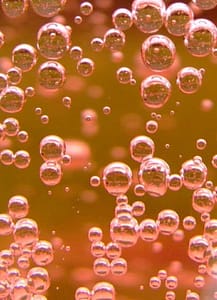 pink bubbles in gold fluid