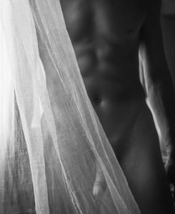 nude man partly behind gauze curtain