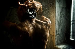 back of man with black hair showering