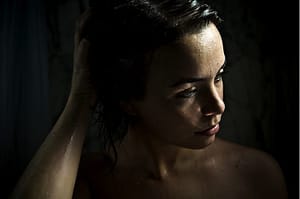 blue-eyed woman in dark shower