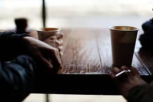 two people at table drinking coffee