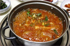 a pot of kimchee stew bubbling on stove