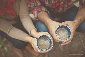 couple with hands holding mugs
