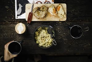 hand on mug on dark table with food