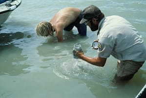 two men collecting river samples for analysis