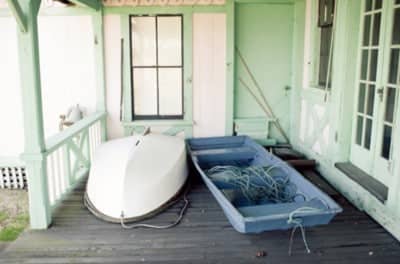 two shallow boats on porch of small house