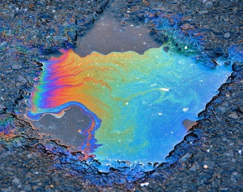rainbow oil reflections on puddle in asphalt