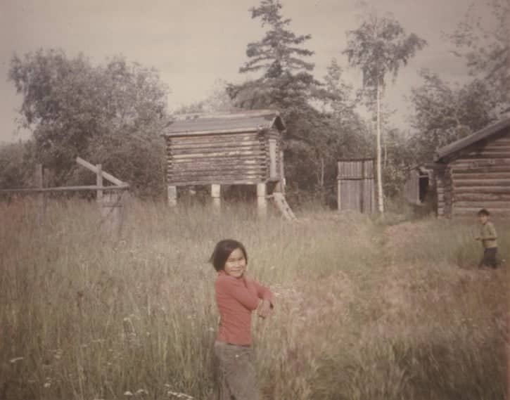kid foreground log cabin background